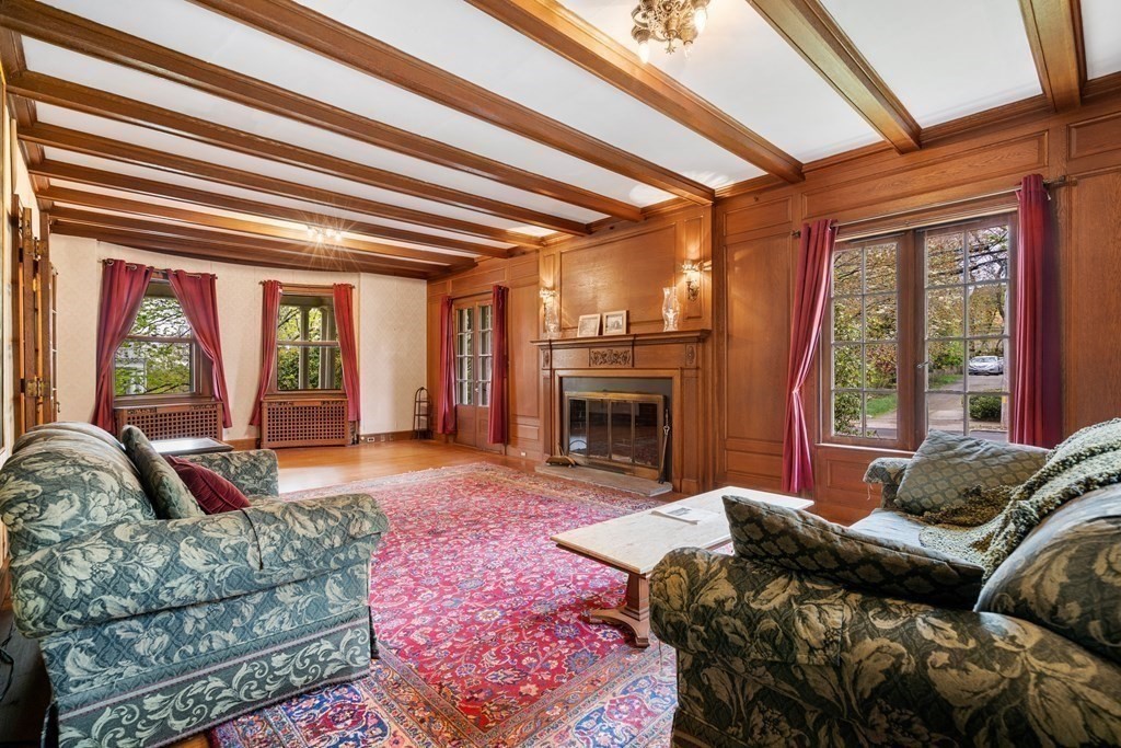 a living room with furniture a fireplace and large windows