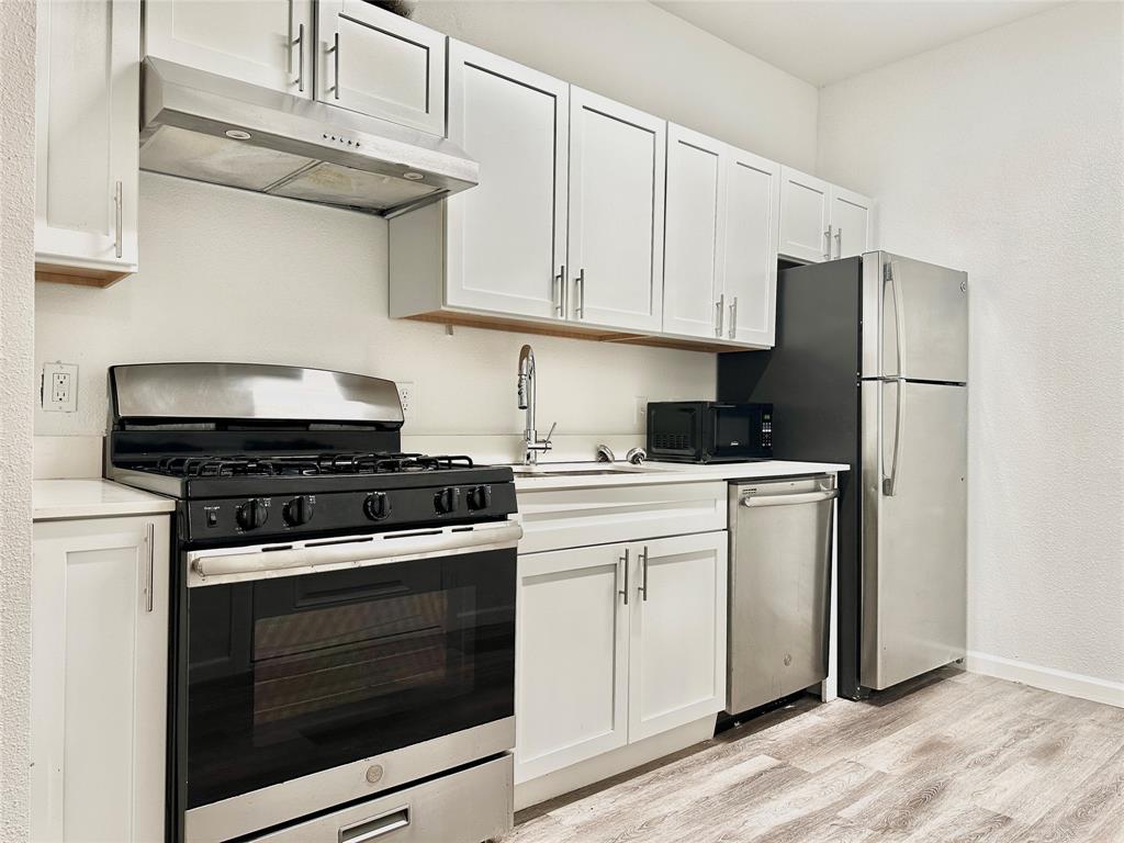911 West 22nd Street, Unit 203 Austin, TX 78705 - Photo 2 of 13 a kitchen with stainless steel appliances granite countertop a stove a refrigerator and cabinets