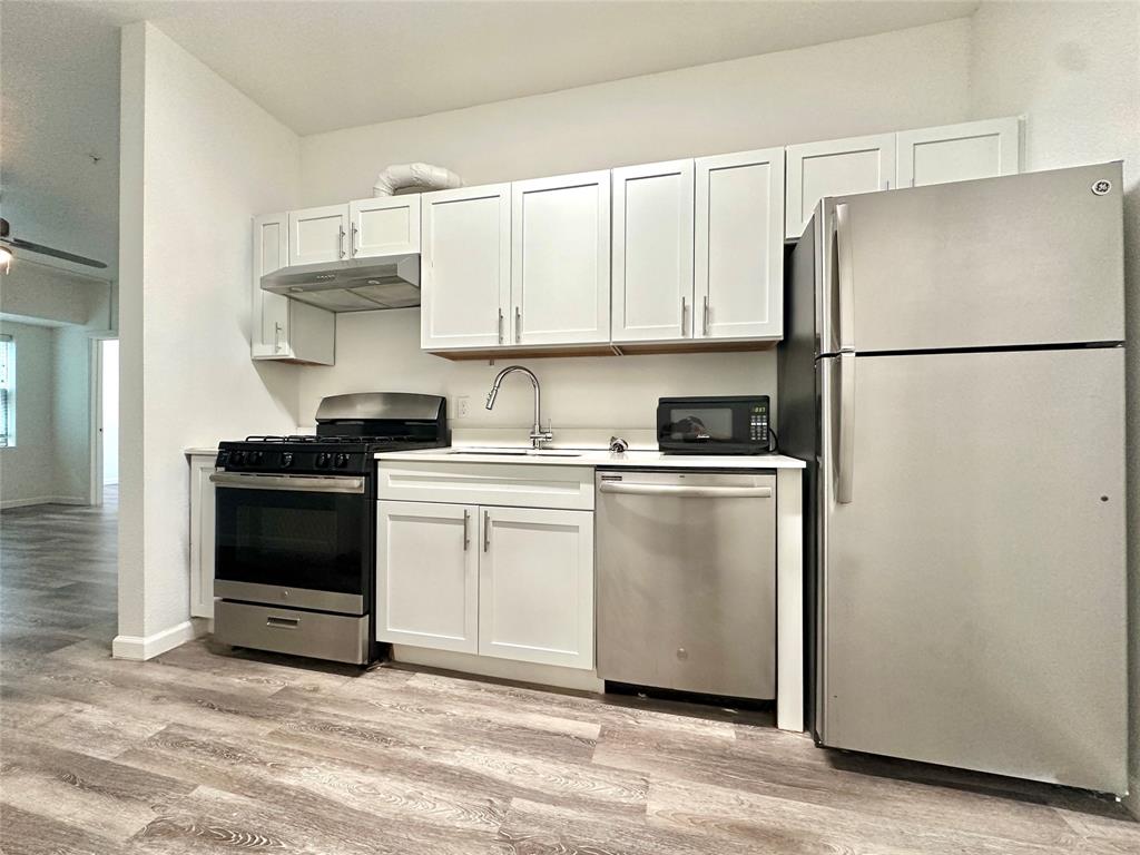 911 West 22nd Street, Unit 203 Austin, TX 78705 - Photo 3 of 13 a kitchen with white cabinets and white appliances