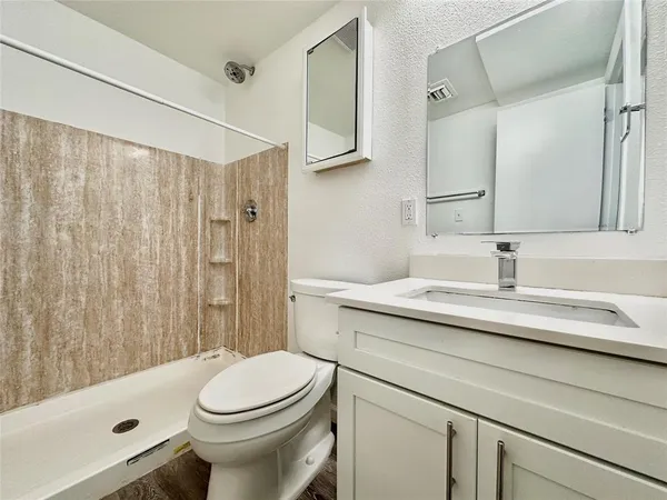 a bathroom with a sink a toilet and shower