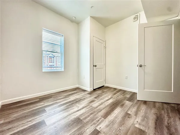 an empty room with wooden floor and a window