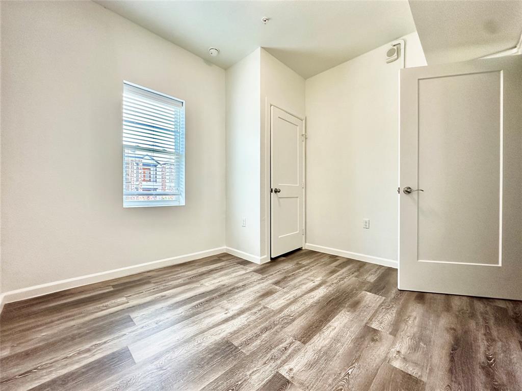 911 West 22nd Street, Unit 203 Austin, TX 78705 - Photo 9 of 13 a view of an empty room with wooden floor and a window