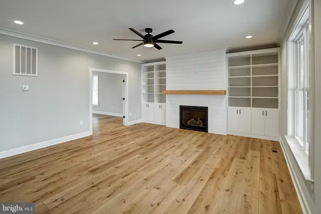 a large kitchen with stainless steel appliances kitchen island granite countertop a stove a sink dishwasher and a refrigerator with wooden floor