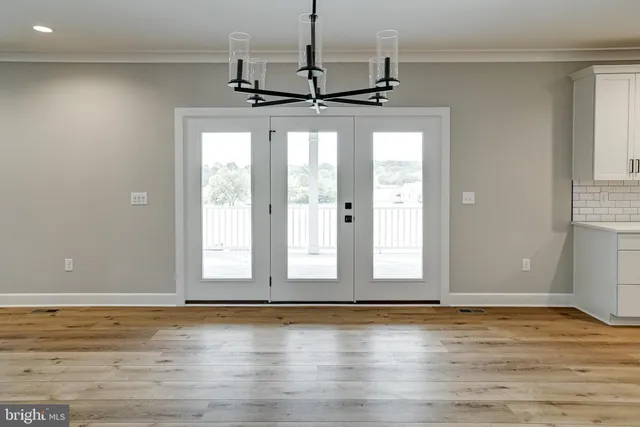 a kitchen with stainless steel appliances granite countertop a refrigerator and a hard wood floor