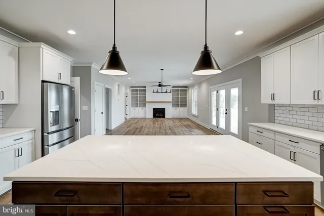 a view of an empty room with wooden floor and window