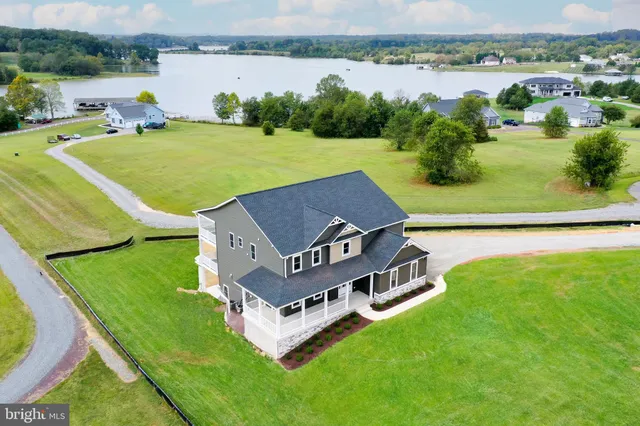 an aerial view of a house with pool big yard and large trees