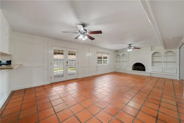 a view of livingroom with a fireplace a ceiling fan and windows