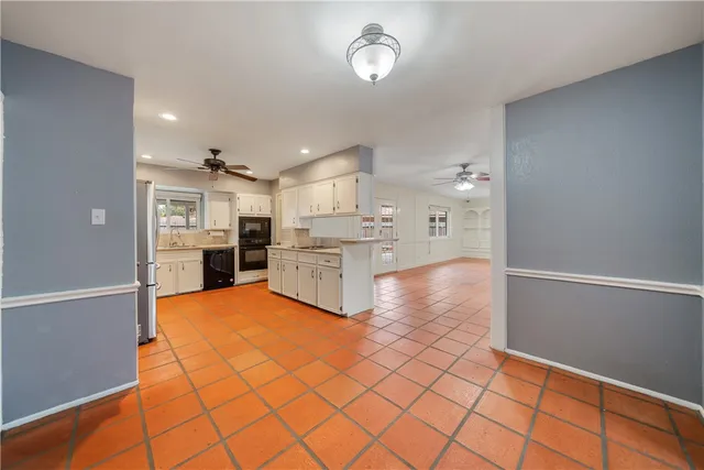 a kitchen with stainless steel appliances kitchen island granite countertop a refrigerator and a stove top oven