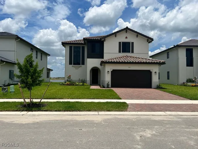 a front view of a house with a garden and yard