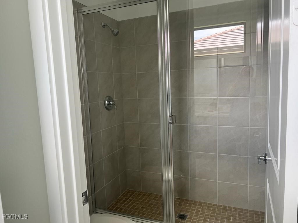 5101 Isidora Lane Ave Maria, FL 34142 - Photo 15 of 33 a bathroom with a glass shower door