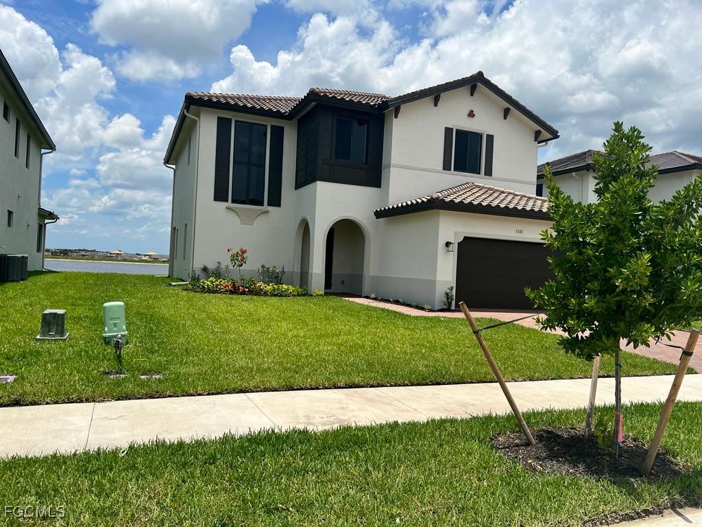 5101 Isidora Lane Ave Maria, FL 34142 - Photo 2 of 33 a front view of a house with a yard and garage