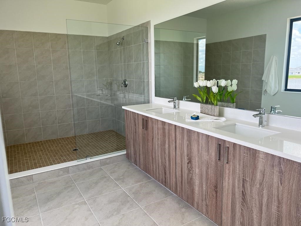 5101 Isidora Lane Ave Maria, FL 34142 - Photo 22 of 33 a bathroom with a shower sink and mirror