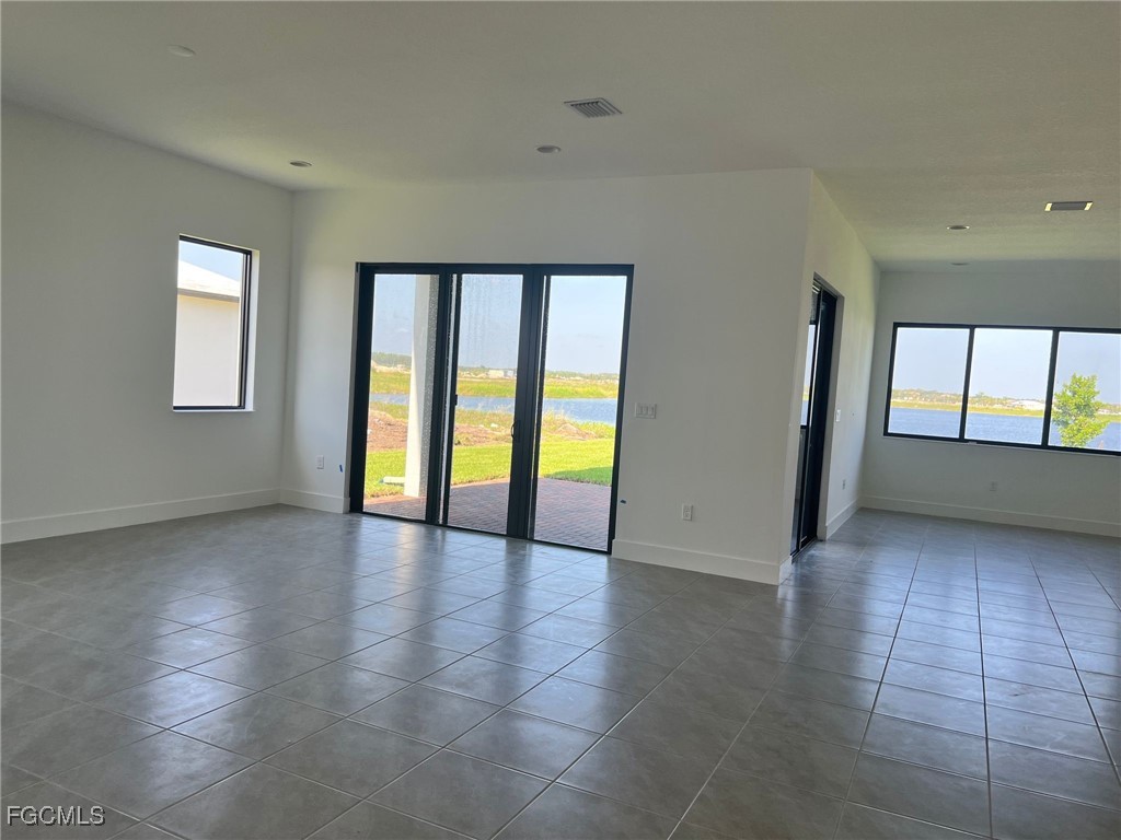 5101 Isidora Lane Ave Maria, FL 34142 - Photo 6 of 33 an empty room with large windows and ceiling fan
