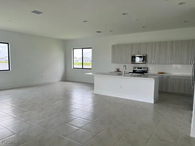 a view of a kitchen with a sink a microwave and cabinets