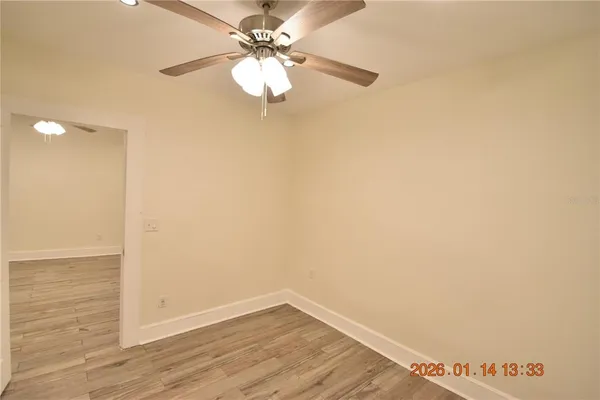 a view of an empty room with wooden floor