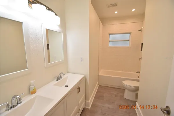 a bathroom with a bathtub sink mirror and toilet