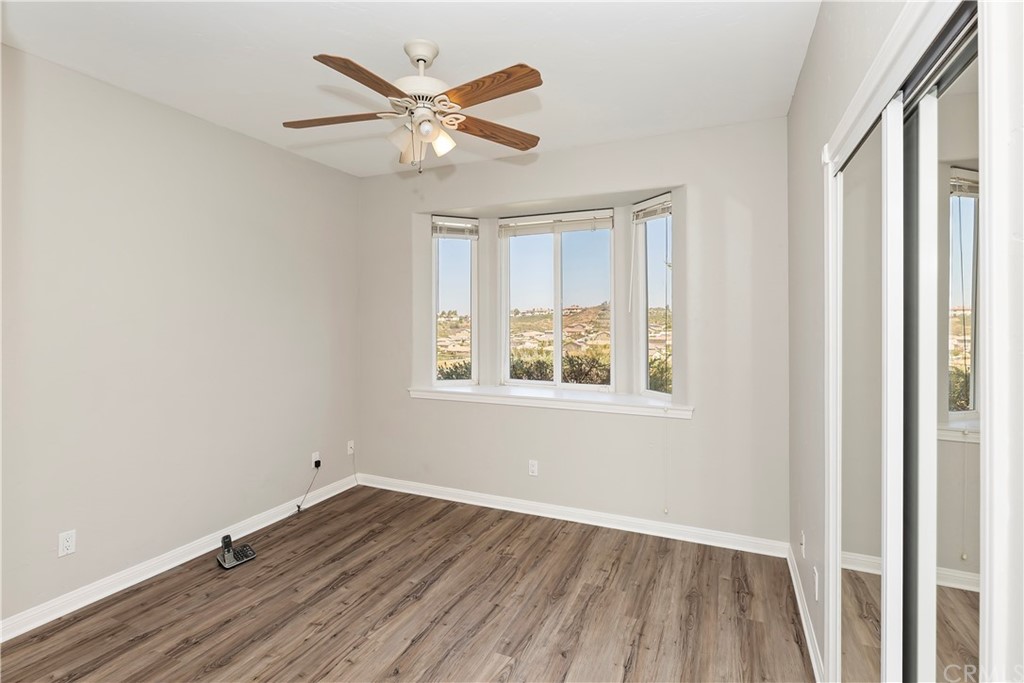 33425 Monte Verde Temecula, CA 92592 - Photo 34 of 68 an empty room with wooden floor fan and windows
