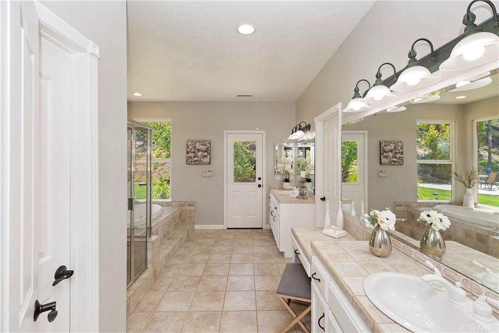 33425 Monte Verde Temecula, CA 92592 - Photo 42 of 68 a spacious bathroom with a granite countertop sink a toilet a mirror and shower