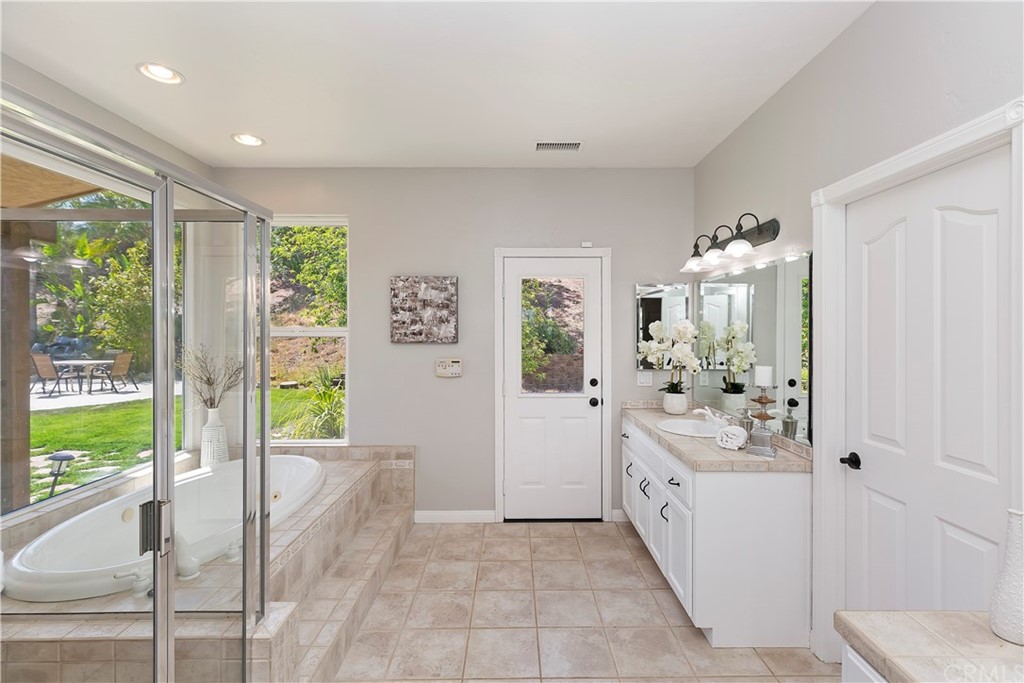 33425 Monte Verde Temecula, CA 92592 - Photo 43 of 68 a spacious bathroom with a double vanity sink and a large mirror