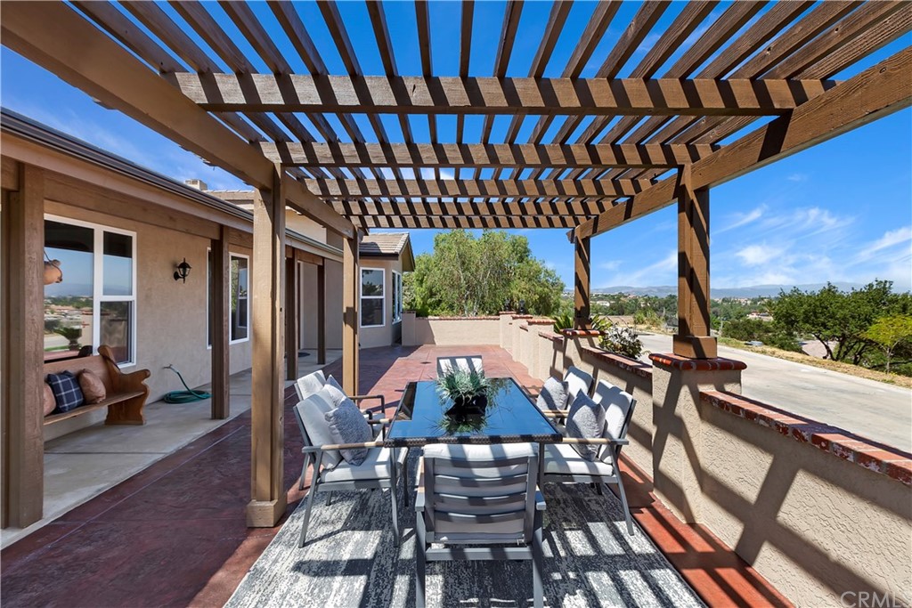 33425 Monte Verde Temecula, CA 92592 - Photo 46 of 68 a view of a patio with table and chairs with wooden floor and fence