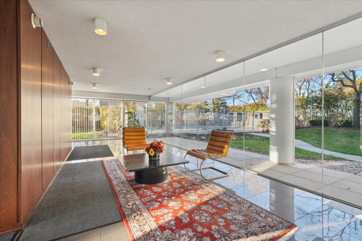 1618 Sheridan Road, Unit PH Wilmette, IL 60091 - Photo 42 of 49 a living room with large windows and a table