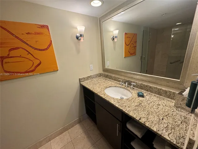 a bathroom with a granite countertop sink and a mirror