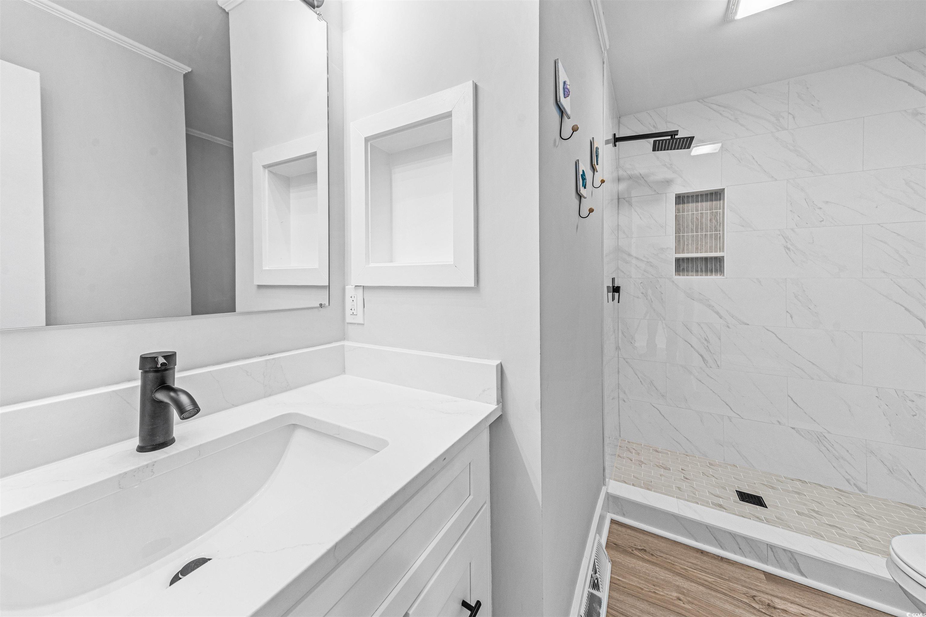 338 State Rd S-26-530 Murrells Inlet, SC 29576 - Photo 29 of 39 Full bathroom featuring a stall shower, wood finished floors, toilet, and vanity
