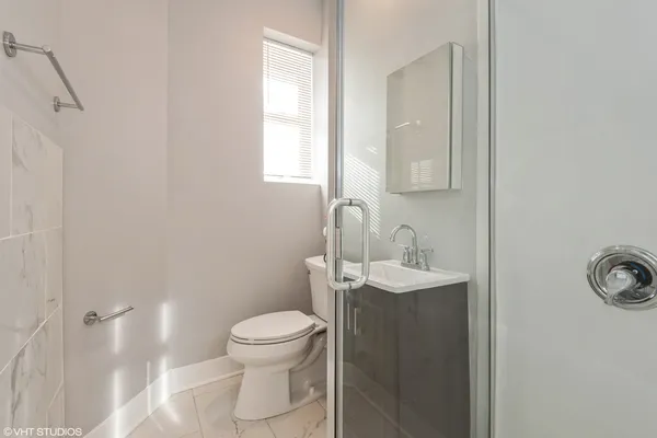 a bathroom with a sink a toilet and shower