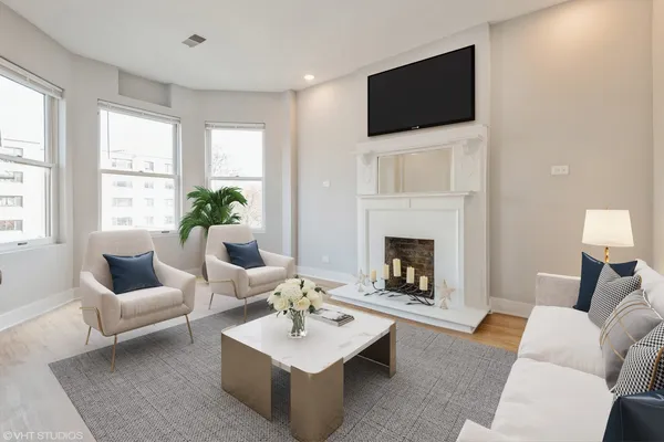 an empty room with wooden floor windows and fireplace