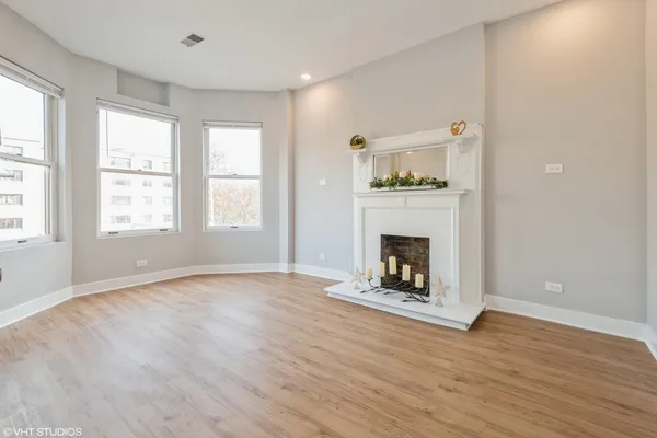 a view of livingroom with wooden floor and a fireplace