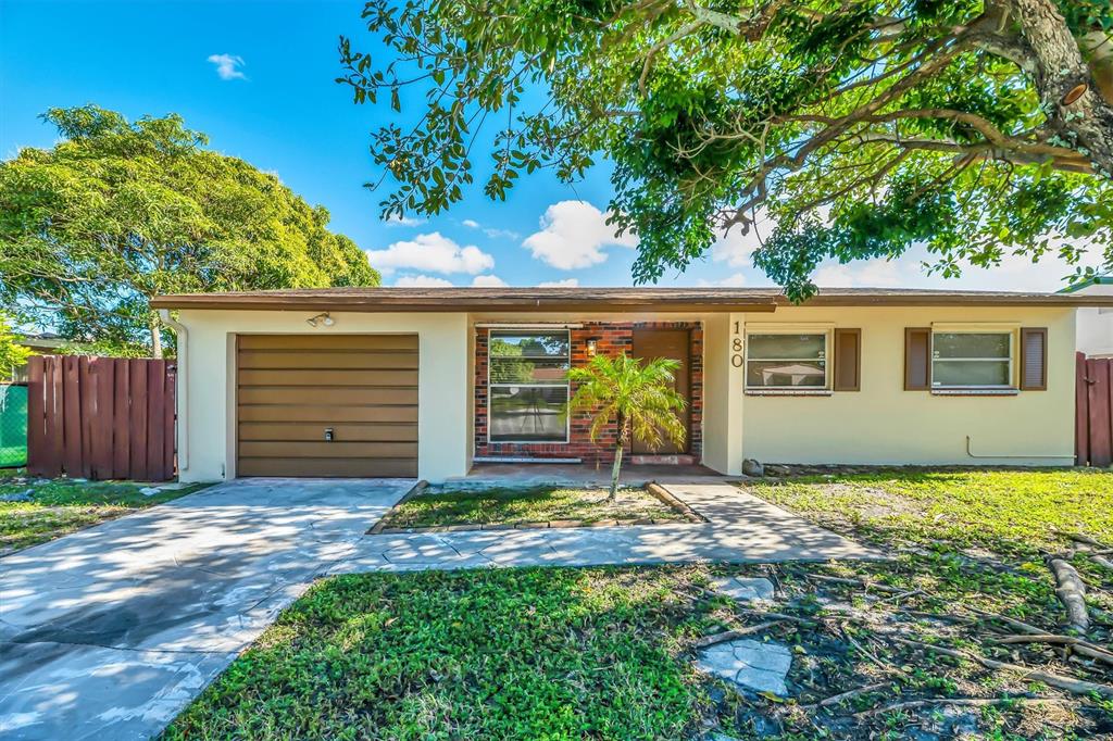 a view of a house with a yard and potted plants