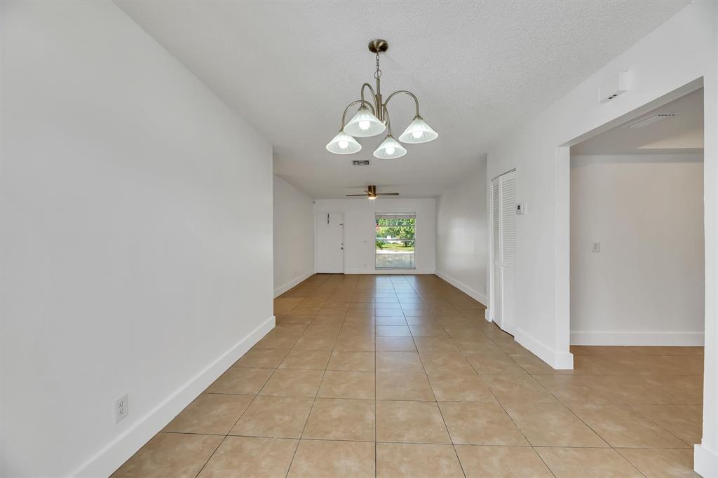 180 Southwest 78th Avenue Margate, FL 33068 - Photo 11 of 40 a view of a room with a chandelier fan and windows