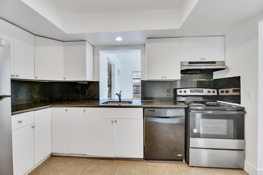 180 Southwest 78th Avenue Margate, FL 33068 - Photo 15 of 40 a kitchen with white cabinets and stainless steel appliances