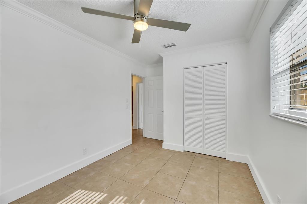 180 Southwest 78th Avenue Margate, FL 33068 - Photo 32 of 40 an empty room with windows and fan