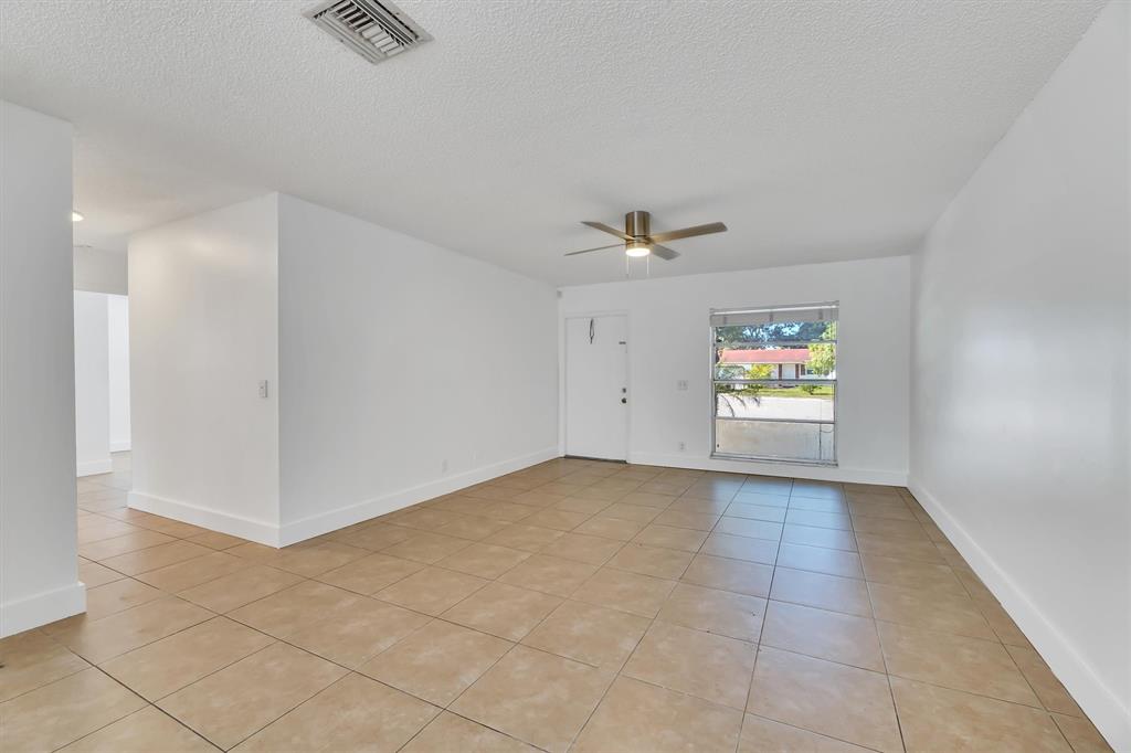 180 Southwest 78th Avenue Margate, FL 33068 - Photo 5 of 40 an empty room with windows and fan