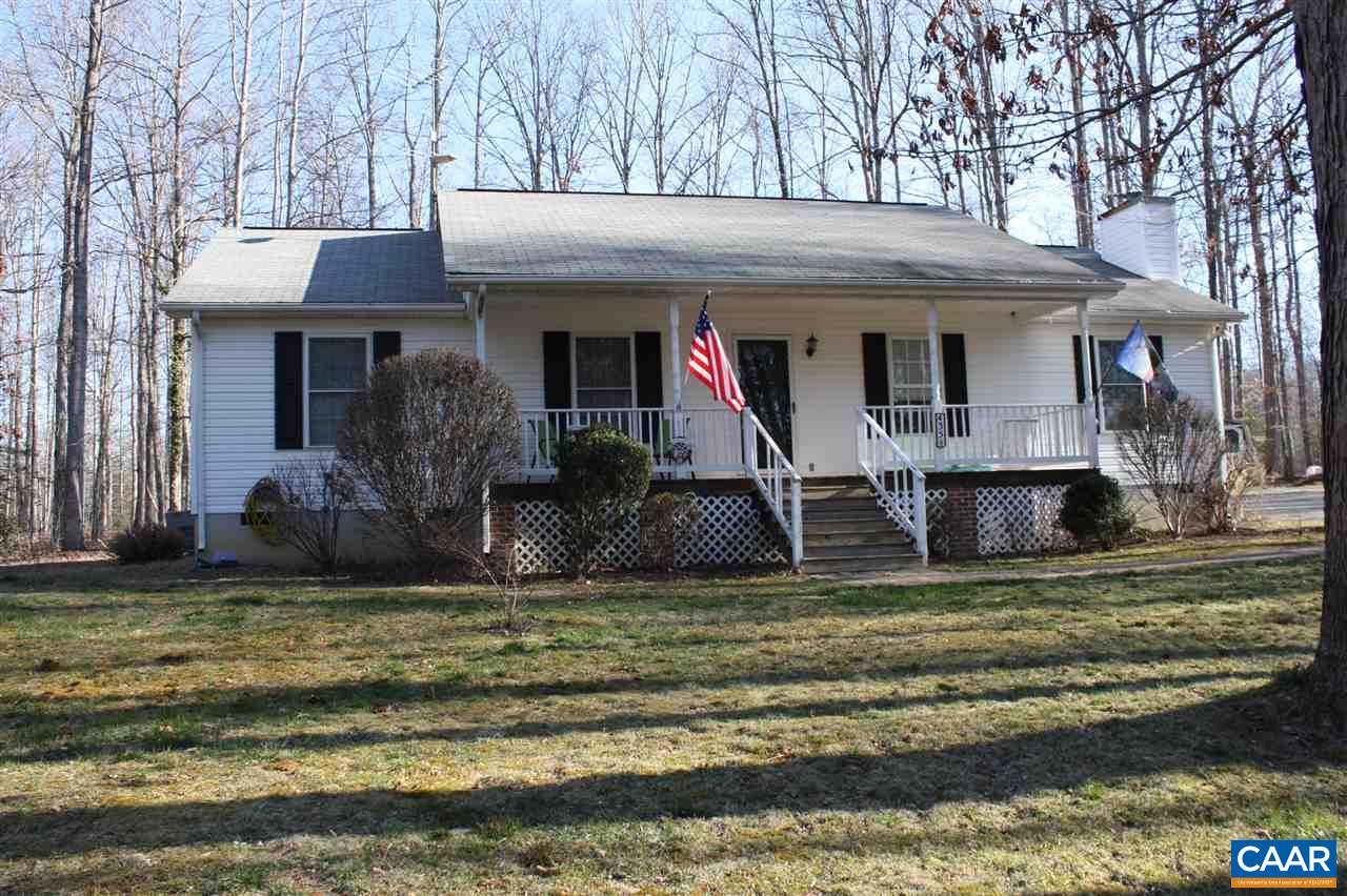 a view of a house with a small yard and large tree