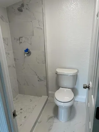a white toilet sitting next to a bath tub