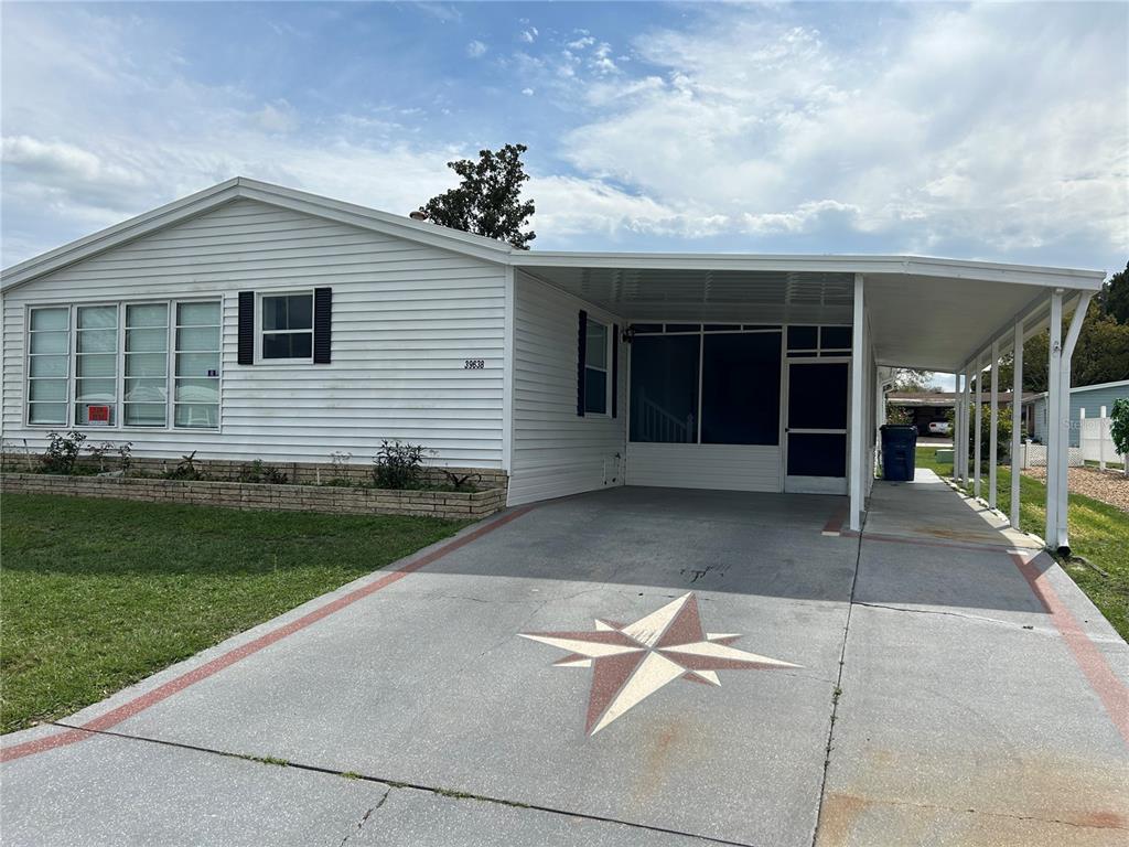 39638 Sunvalley Drive Zephyrhills, FL 33542 - Photo 2 of 14 a front view of a house with a garden and yard