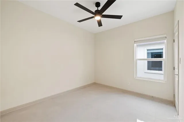 an empty room with a window and a ceiling fan
