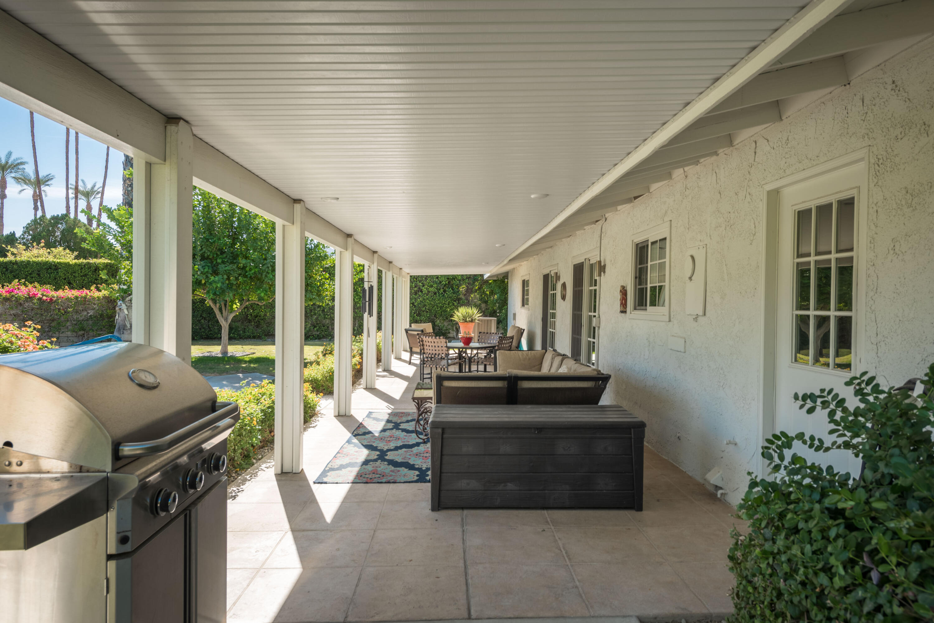 37116 Palmdale Road Rancho Mirage, CA 92270 - Photo 32 of 41 a view of a patio with couches potted plants and floor to ceiling window