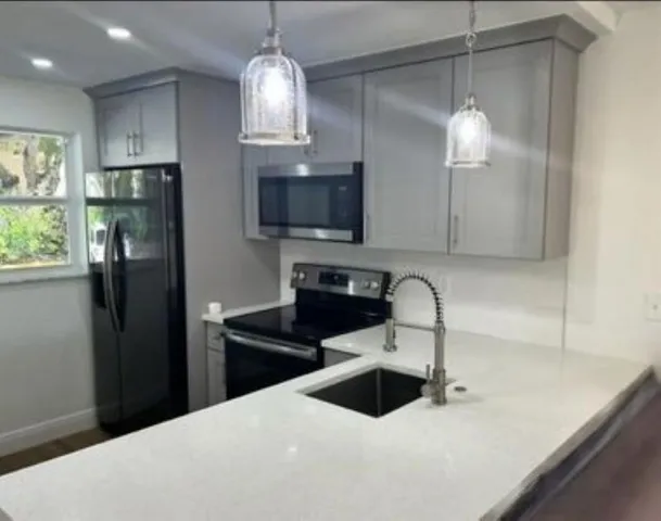 a kitchen with stainless steel appliances a sink refrigerator and microwave