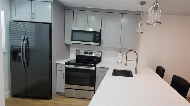 a kitchen with stainless steel appliances a refrigerator stove and microwave