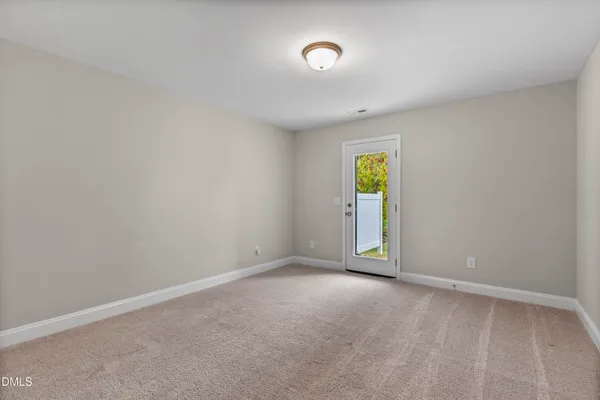 an empty room with window and mirror