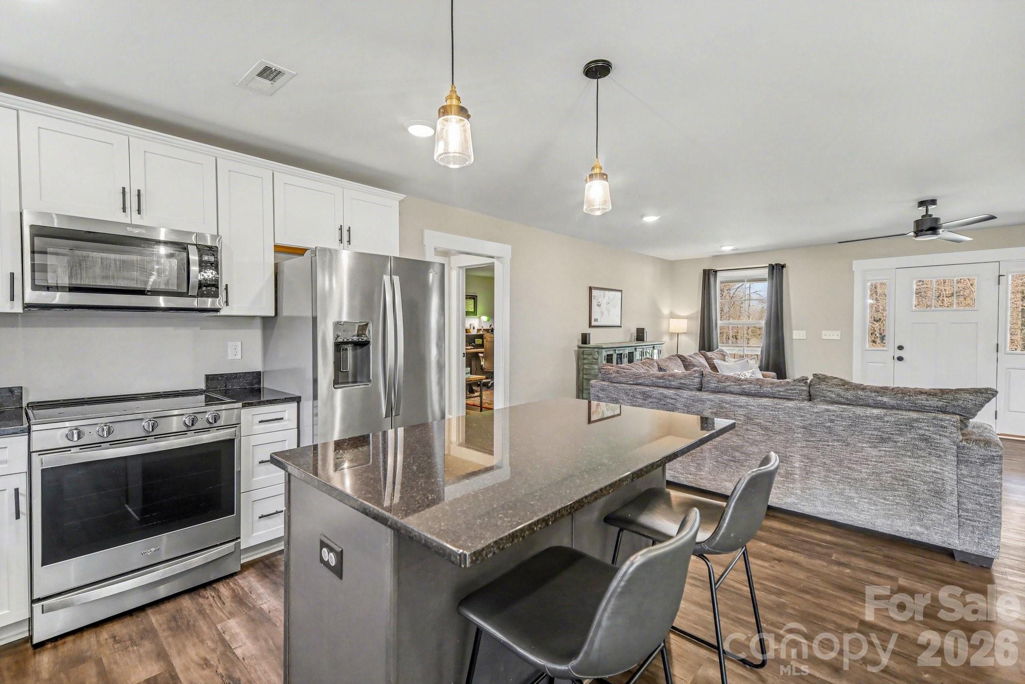 310 Old Hardin Road Dallas, NC 28034 - Photo 11 of 37 a kitchen with stainless steel appliances granite countertop a stove refrigerator and cabinets
