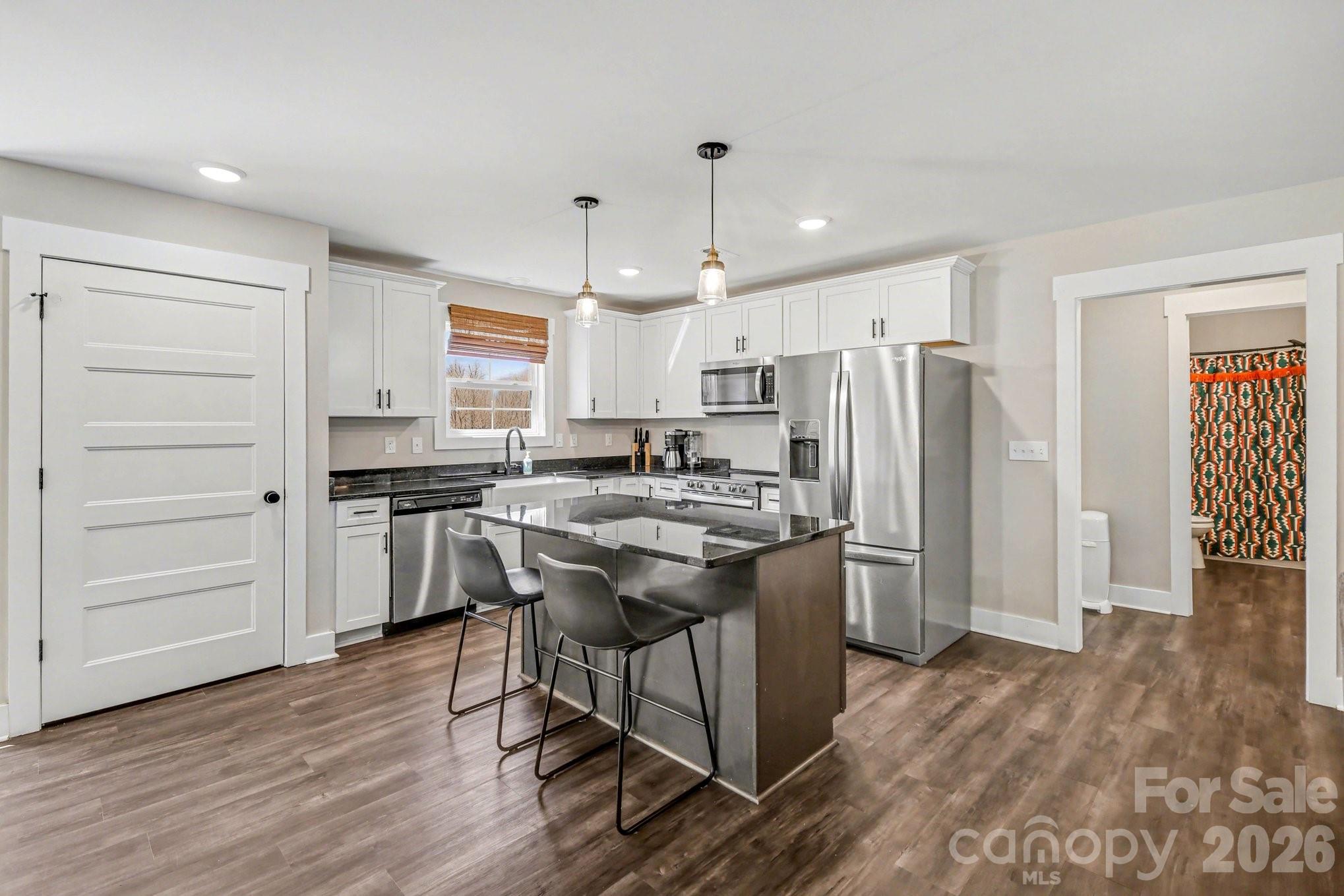 310 Old Hardin Road Dallas, NC 28034 - Photo 12 of 37 a kitchen with stainless steel appliances granite countertop a refrigerator a stove a sink dishwasher and a refrigerator with wooden floor