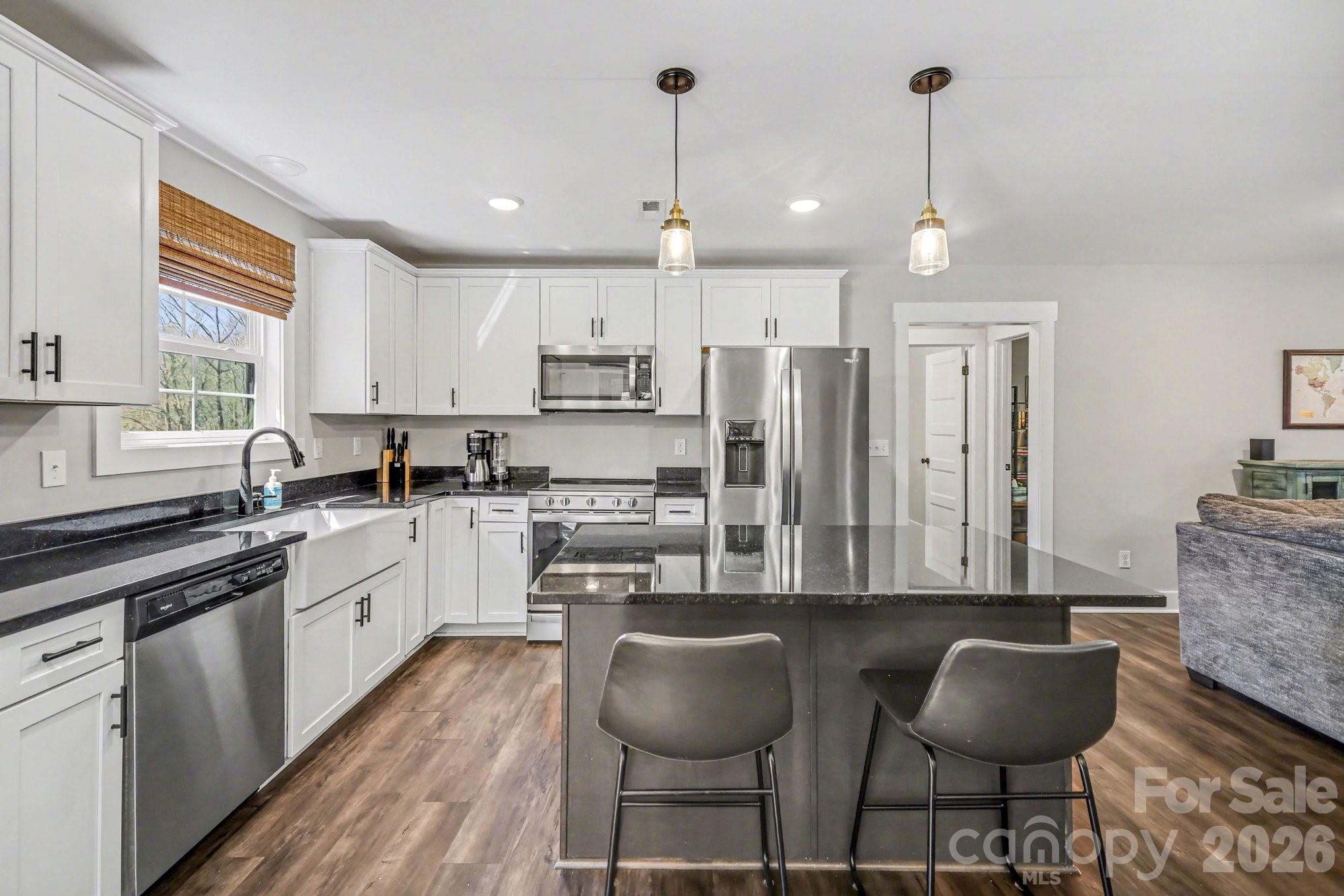 310 Old Hardin Road Dallas, NC 28034 - Photo 14 of 37 a kitchen with stainless steel appliances granite countertop a stove a sink a center island and cabinets
