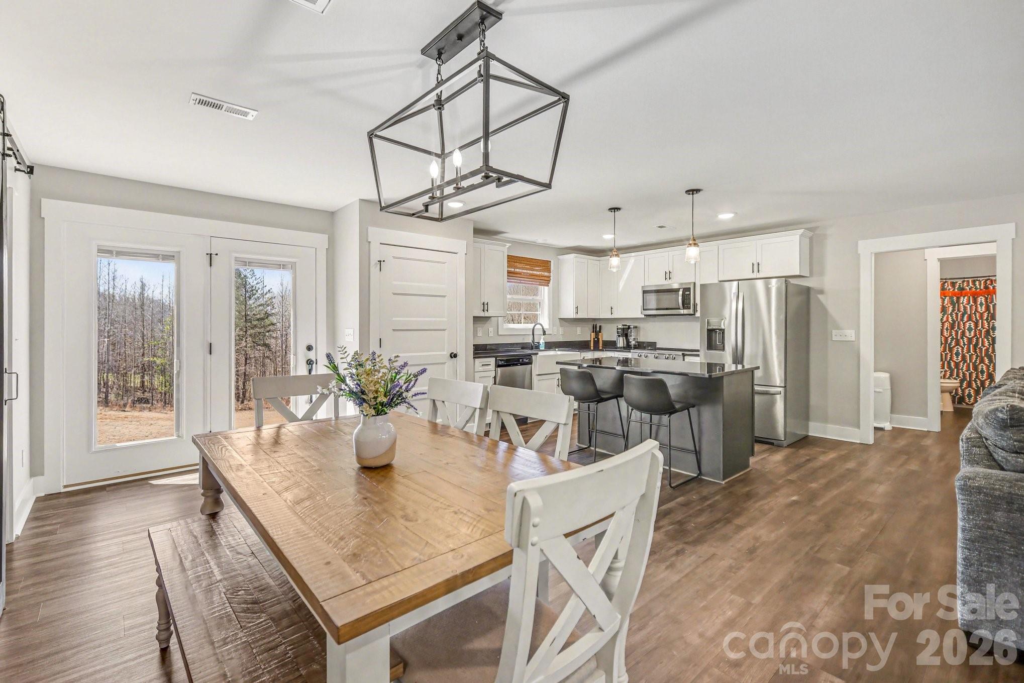 310 Old Hardin Road Dallas, NC 28034 - Photo 16 of 37 a view of a dining room and livingroom with furniture wooden floor a chandelier
