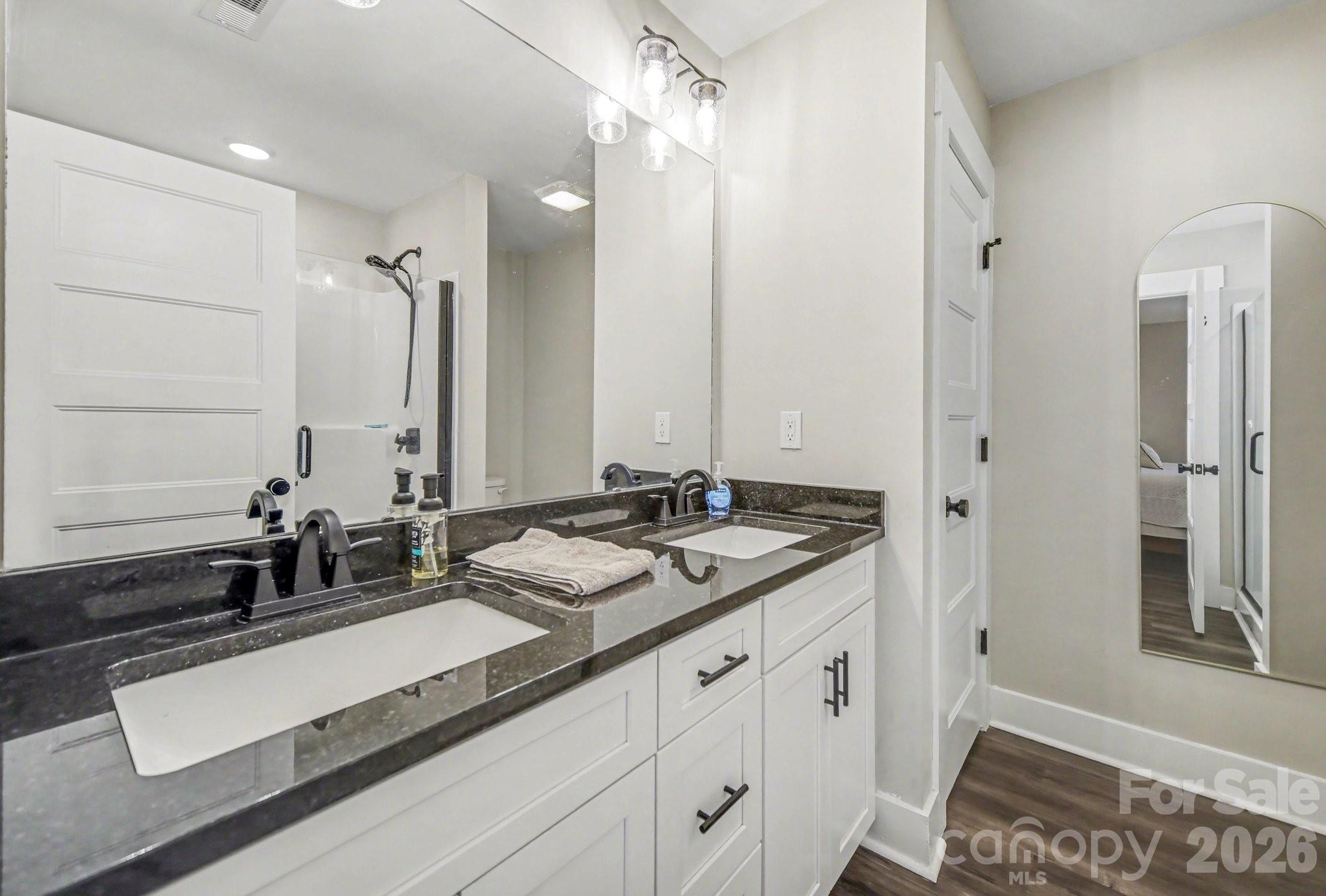310 Old Hardin Road Dallas, NC 28034 - Photo 25 of 37 a bathroom with a double vanity sink a mirror and a shower