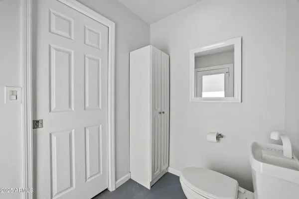 a white toilet sitting next to a bathroom sink