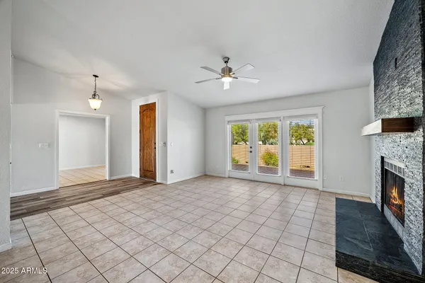 an empty room with windows cabinet and fireplace